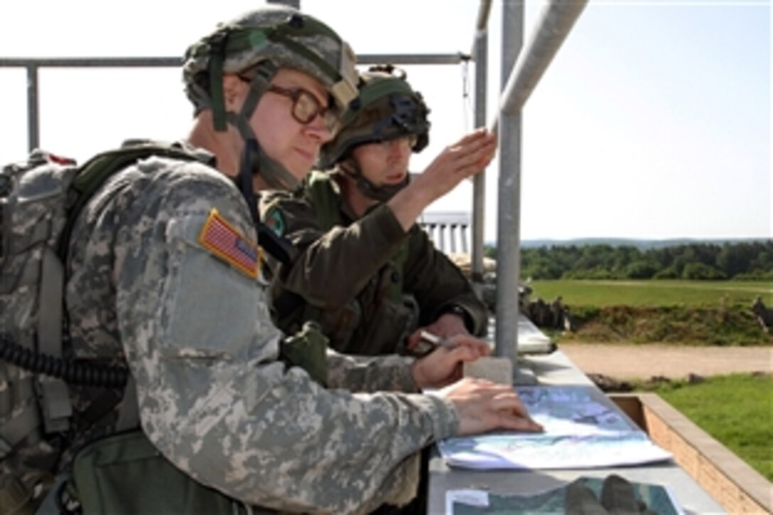 Austrian Sgt. Robert Krassnig, right, and a U.S. soldier discuss positions while defending an operating base during Exercise Combined Resolve II at the Joint Multinational Readiness Center in Hohenfels, Germany, May 22, 2014. The U.S. soldiers are assigned to the Massachusetts National Guard's Company C, 1st Battalion, 182nd Infantry Regiment. 