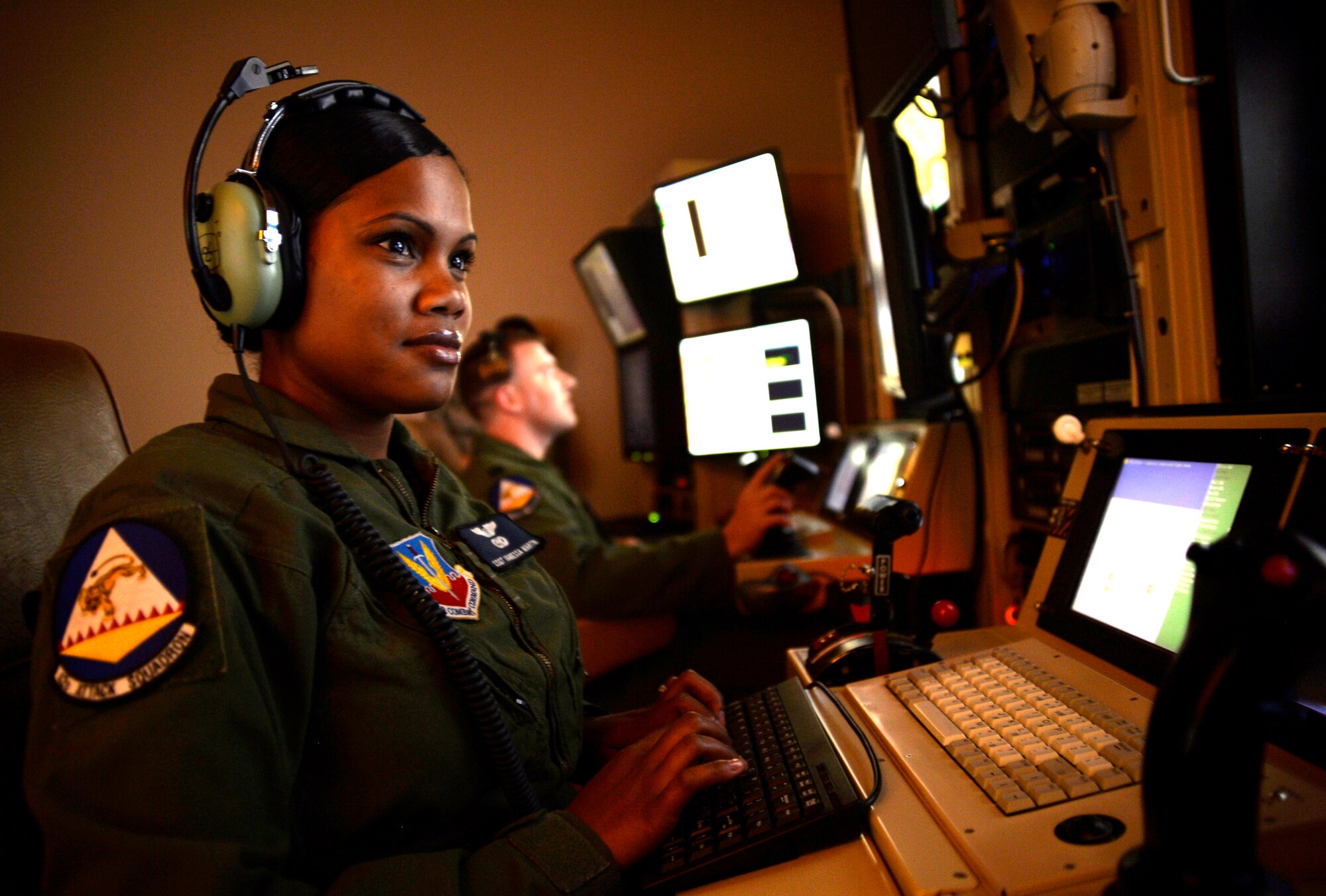 Staff Sgt. Vanessa, 42nd Attack Squadron sensor operator, front, and Capt. Andrew, 18th Reconnaissance Squadron pilot, follow a vehicle with a remotely piloted aircraft in a flight training simulator May 28, 2014. The two-person crew was selected to fly the 65th air combat patrol, an initiative set by then Secretary of Defense Robert Gates Dec. 23, 2009 (Last names have been withheld for security purposes). (U.S. Air Force photo by Staff Sgt. Adawn Kelsey/Released)