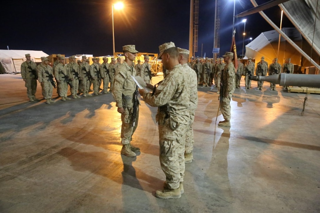 Corporal Devin Huff, center-left, a native of Grander, Indiana, stands at attention while his promotion warrant is read aloud during a promotion ceremony aboard Camp Bastion, Afghanistan, June 1, 2014. Huff, an assaultman with Bravo Company, 1st Battalion, 7th Marine Regiment, and 20 other lance corporals with the battalion were promoted, June 1 and 2. (U.S. Marine Corps photo by Cpl. Joseph Scanlan / released)