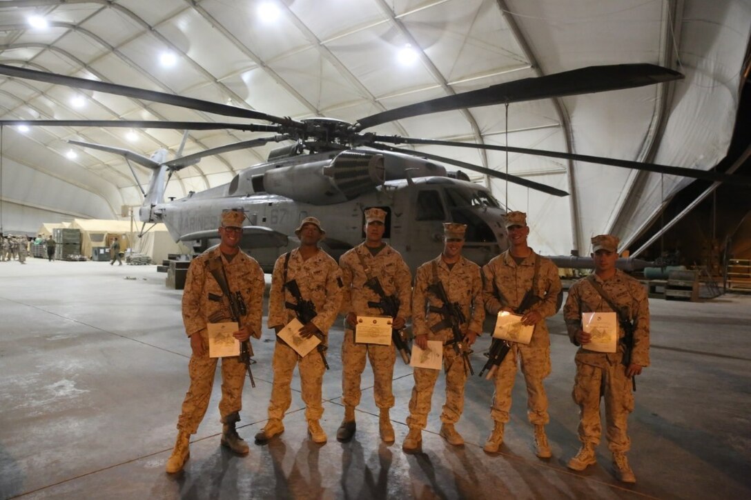 Newly promoted Marines with Bravo Company, 1st Battalion, 7th Marine Regiment, pose for a photo in front of a CH-53E Super Stallion after a promotion ceremony aboard Camp Bastion, Afghanistan, June 1, 2014. Twenty-eight Marines with the battalion were promoted to the ranks of corporal and sergeant, June 1 and 2.  (U.S. Marine Corps photo by Cpl. Joseph Scanlan / released)