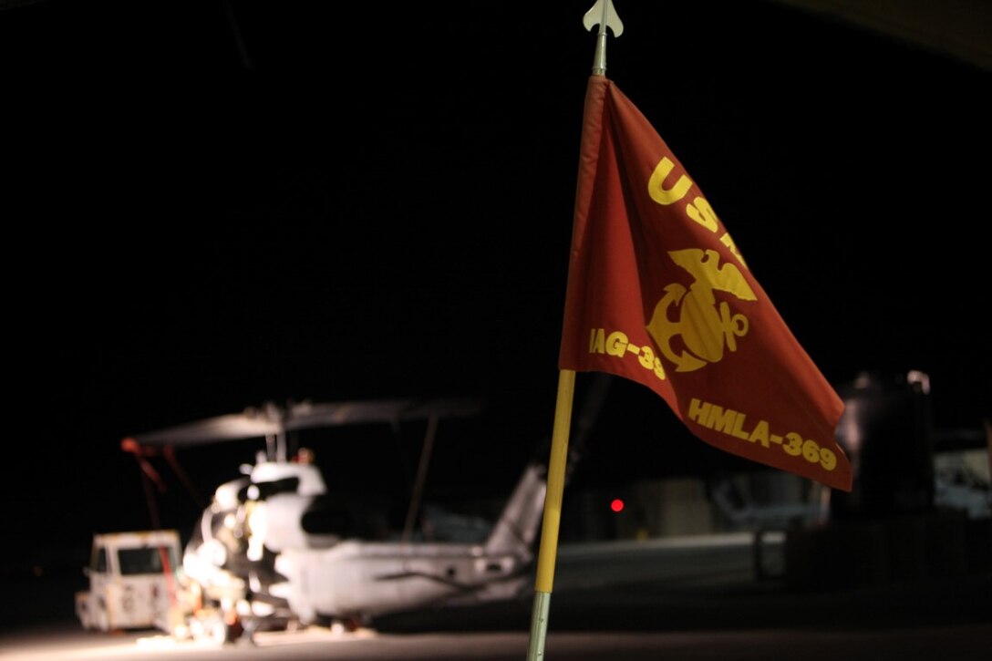 The guidon for Marine Light Attack Helicopter Squadron 369 flies for the last time just before a midnight transfer of authority ceremony aboard Camp Bastion, Afghanistan, May 23, 2014. Since Vietnam, the “Gunfighters” of HMLA-369 have proven themselves a versatile unit ready to support the Marine Air Ground Task Force time and again in combat and humanitarian efforts around the globe. Their final missions complete in support of Operation Enduring Freedom, the squadron from Marine Corps Air Station Camp Pendleton, Calif., transferred authority to HMLA-467, currently deployed from MCAS Cherry Point, N.C. (U.S. Marine Corps Photo By: Sgt. Frances Johnson/Released)