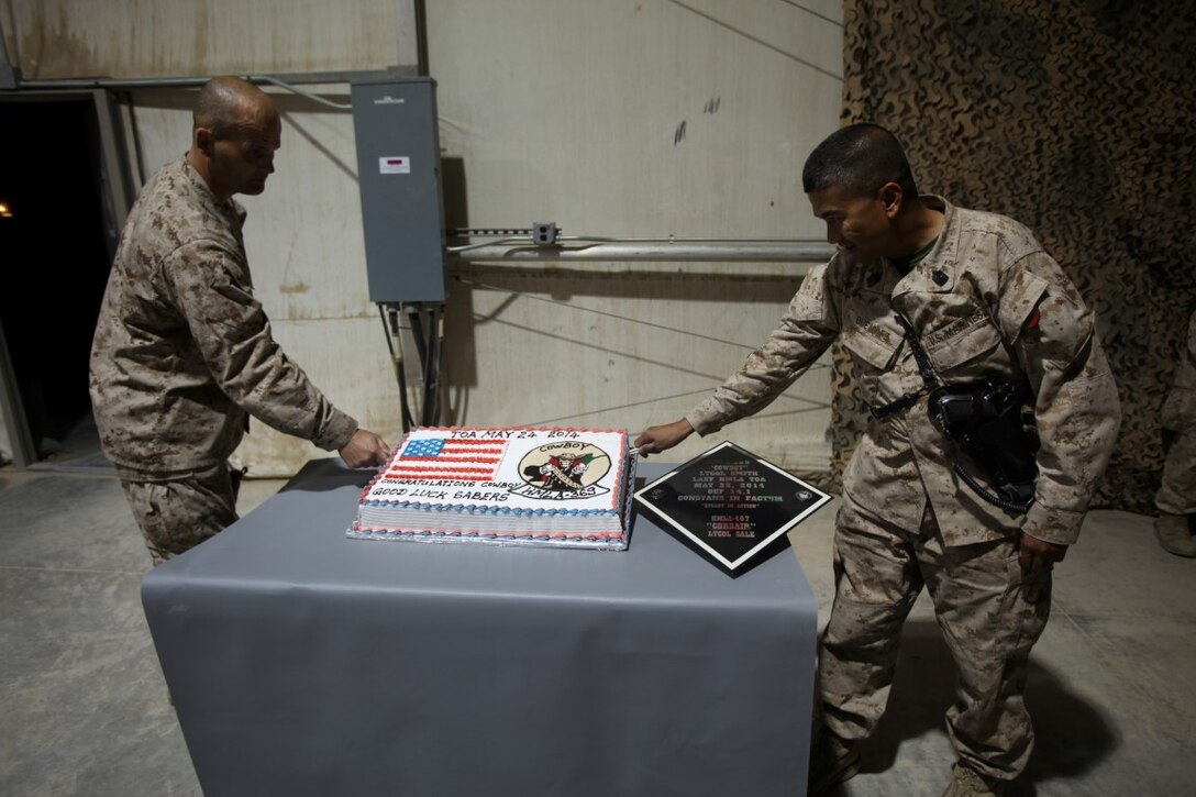Sergeant Maj. John Kennedy, left, sergeant major of HMLA-467, and Sgt. Maj. Larry Buenafe, sergeant major of HMLA-369, make the first cuts in a cake celebrating the transfer of authority from HMLA-369 to HMLA-467 after a ceremony aboard Camp Bastion, Afghanistan, May 24, 2014. Marine Light Attack Helicopter Squadron 467 has only been a squadron for five years and is on its first combat deployment since its establishment. Their final missions complete in support of Operation Enduring Freedom, the squadron from Marine Corps Air Station Camp Pendleton, Calif., transferred authority to HMLA-467, currently deployed from MCAS Cherry Point, N.C. (U.S. Marine Corps Photo By: Sgt. Frances Johnson/Released)