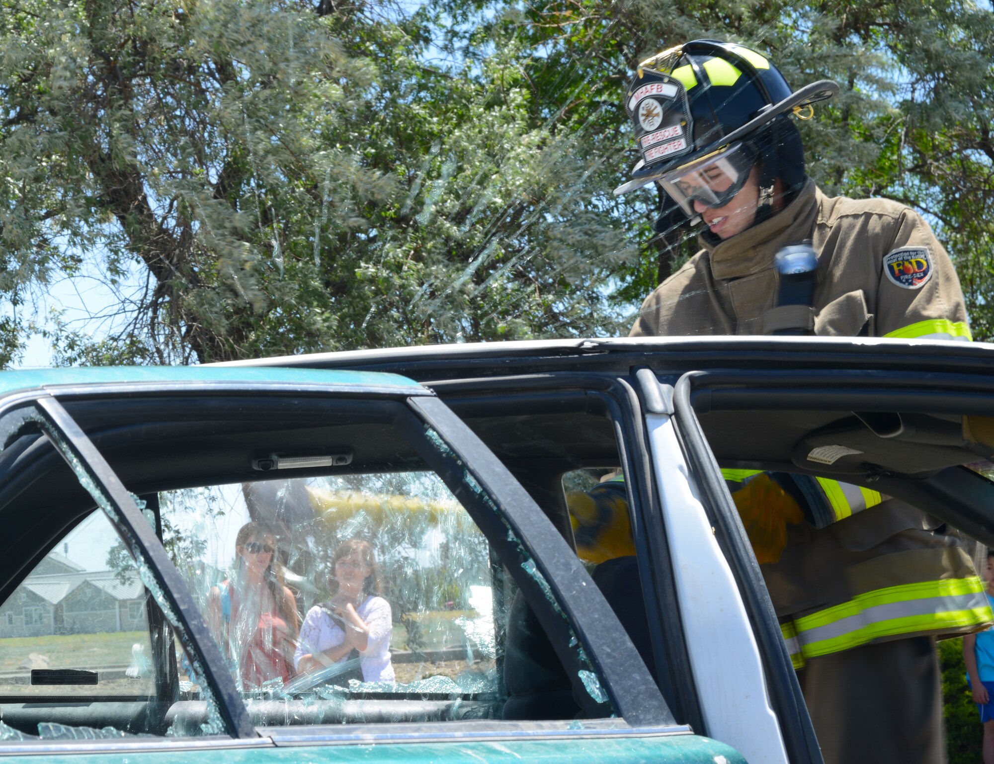 Airman 1st Class Alex Desimone, 366th Civil Engineering Squadron firefighter, breaks the window of a vehicle June 6, 2014, at Mountain Home Air Force Base, Idaho. Members of the Mountain Home AFB fire department demonstrated life-saving procedures during the safety fair in the parking lot of the base exchange. (U.S. Air Force photo by Senior Airman Benjamin Sutton/Released)