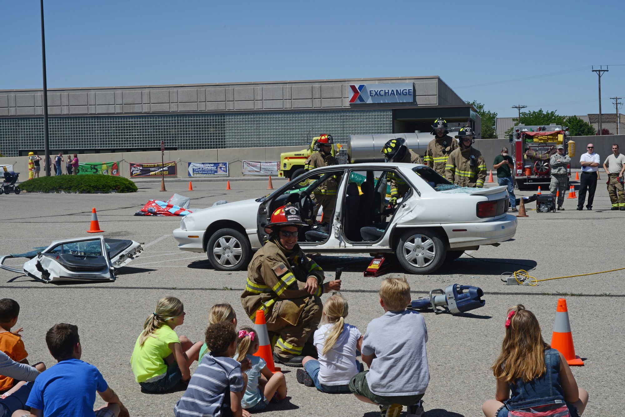 Members of the 366th Civil Engineering Squadron Fire Department demonstrate how to quickly enter a car in case of a vehicle accident hose June 6, 2014, at Mountain Home Air Force Base, Idaho. Mountain Home AFB held a safety fair in the parking lot of the base exchange in an effort to educate the Gunfighter community on specific summer safety concerns. (U.S. Air Force photo by Senior Airman Benjamin Sutton/Released)