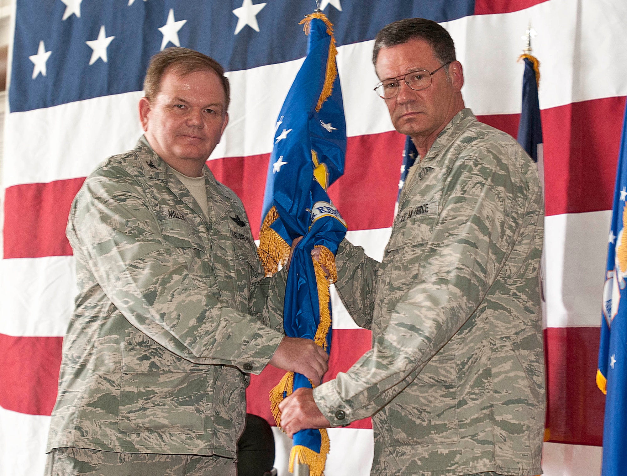 National Guard Deputy Adjutant General for Air, Brig. Gen. Derek Hill is handed a flag from 185th Air Refueling Wing Commander Col. Brian Miller, who relinquished his command of the unit, during a Change-of-Command ceremony in Sioux City, Iowa on June 7, 2014. Miller relinquished his command after 7 years to Col. Larry Christensen. (Official Air National Guard Photo by Tech Sgt. Oscar Sanchez/Released)