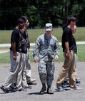 2nd Lt. Christopher Sullivan, 2nd Bomb Wing Public Affairs officer, looks at the feet of recruits to ensure they are properly positioned during a drill procedure on Barksdale Air Force Base, La., June 7, 2014. Sullivan, a former Military Training Instructor, has pushed thousands of trainees through Air Force Basic Military Training. (U.S. Air Force photo/Senior Airman Benjamin Gonsier)