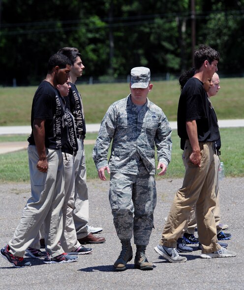 2nd Lt. Christopher Sullivan, 2nd Bomb Wing Public Affairs officer, looks at the feet of recruits to ensure they are properly positioned during a drill procedure on Barksdale Air Force Base, La., June 7, 2014. Sullivan, a former Military Training Instructor, has pushed thousands of trainees through Air Force Basic Military Training. (U.S. Air Force photo/Senior Airman Benjamin Gonsier)