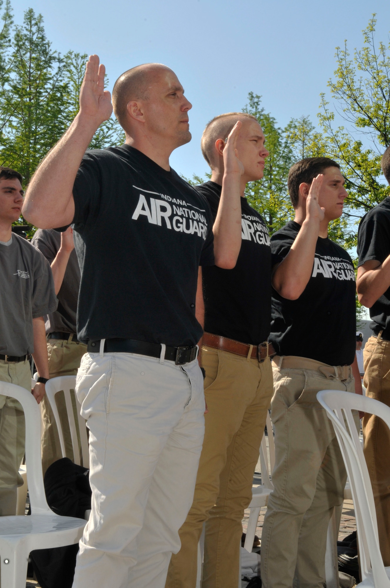 Patrick (left) and Taylor Affolder (center), recent recruits of the 122nd Fighter Wing, Fort Wayne Air National Guard Base, raise their hands for the Oath of Enlistment during a mass enlistment ceremony on May 18, 2014 at the Indianapolis Motor Speedway. The father and son duo could find no better way to begin their military careers than to enlist together at the annual ceremony held  during Armed Forces Weekend. (Air National Guard photo by Airman 1st Class Justin Andras/Released)