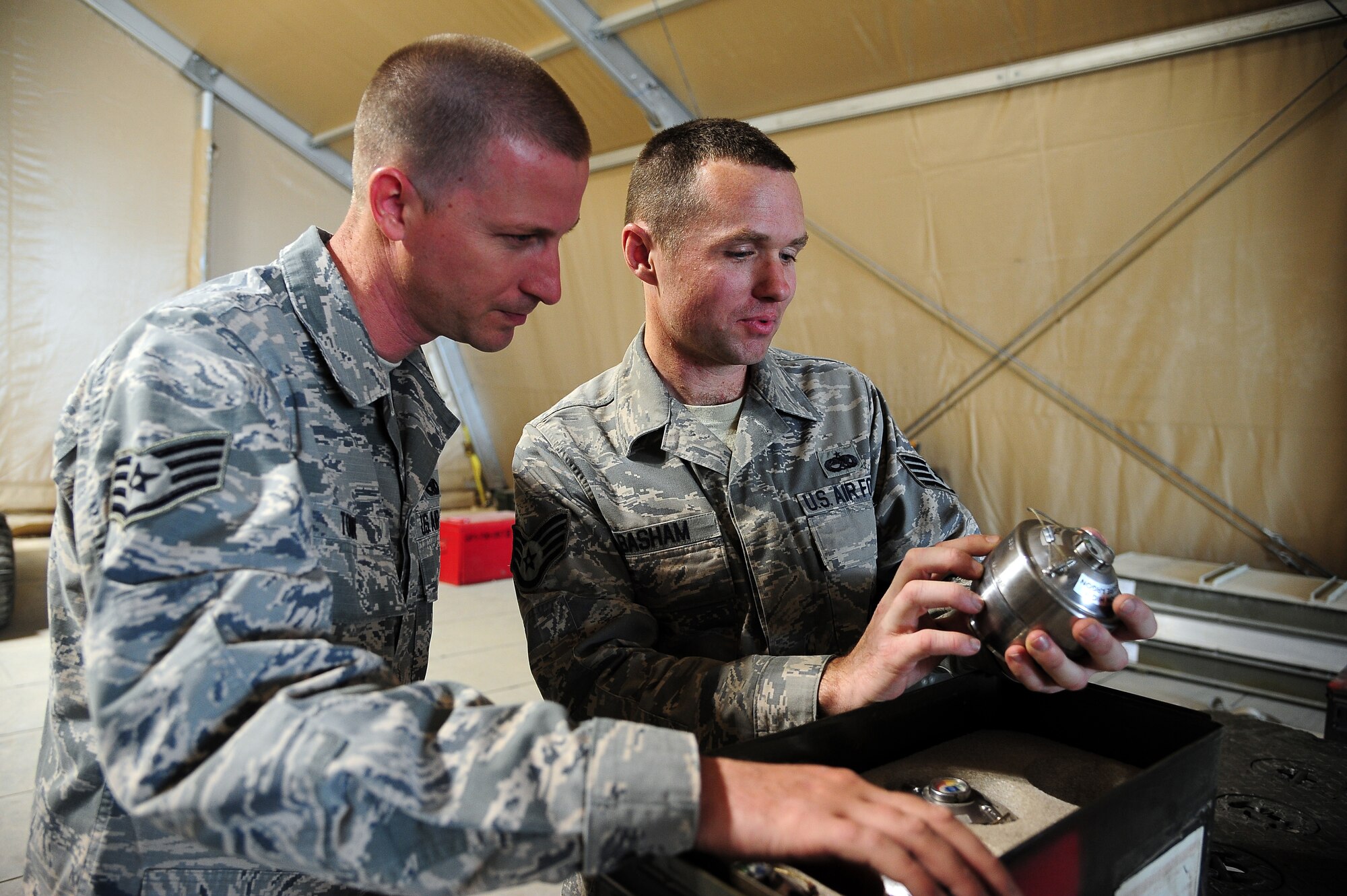 U.S. Air Force Staff Sgt. Joshua Tobin, left, and Staff Sgt. Joshua Basham, munitions shift leads from the 35th Maintenance Squadron at Misawa Air Base, Japan, verify argon levels during Exercise Eager Lion June 4, 2014, at an air base in northern Jordan. Throughout the two-week exercise, Ammo Airmen supported F-16 Fighting Falcons by ensuring they were properly armed when participating in relationship-strengthening scenarios with partner nations. (U.S. Air Force photo by Staff Sgt. Brigitte N. Brantley/Released)