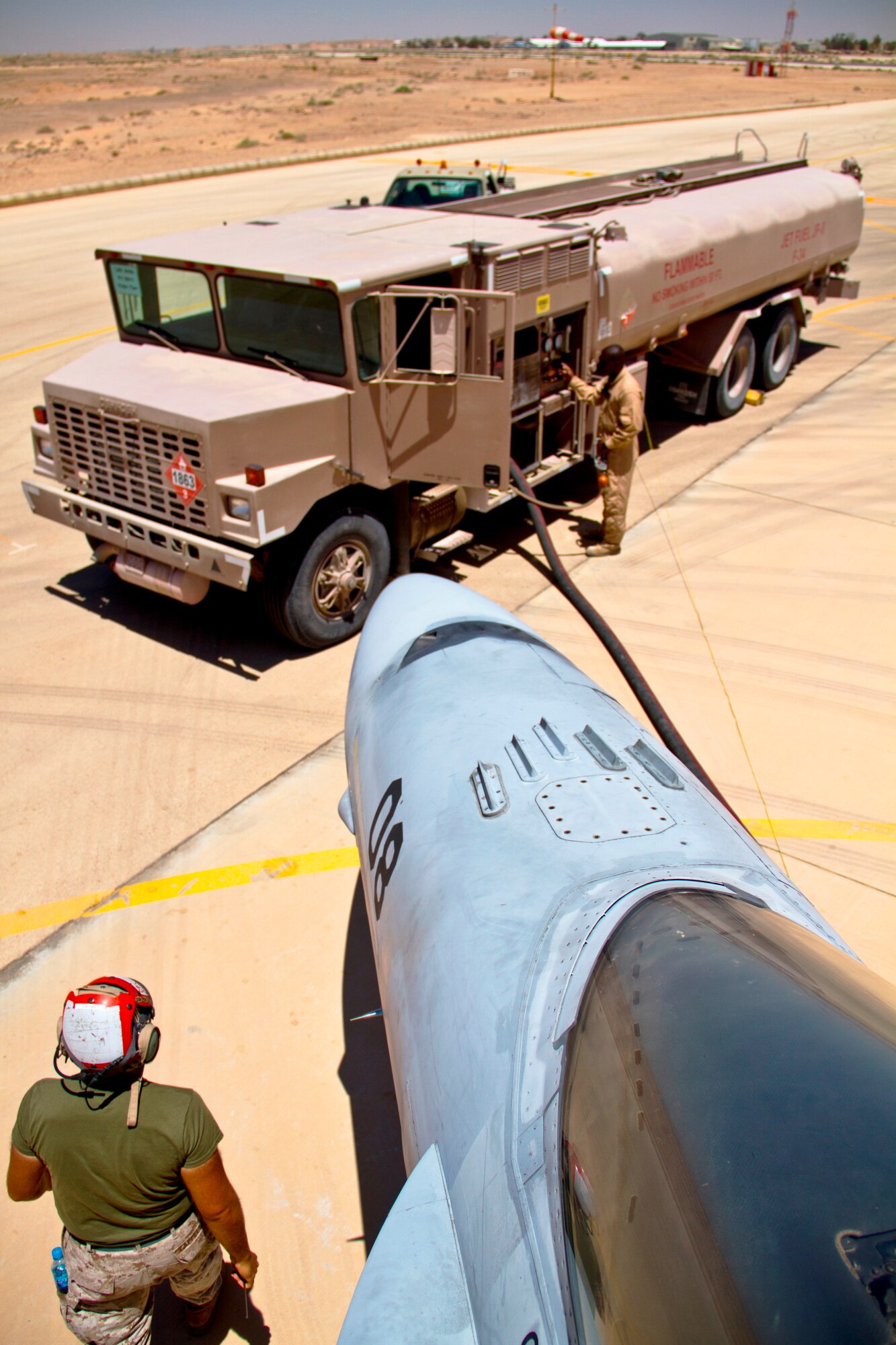 U.S. Marines from Marine Fighter Attack Squadron 314 at Marine Corps Air Station Miramar, Calif., refuel an F-18 Hornet during Exercise Eager Lion June 1, 2014, at an air base in northern Jordan. Maintainers played a vital role in Eager Lion, ensuring the fighter aircraft were constantly flight-ready. (U.S. Air Force photo by Staff Sgt. Tyler McLain/Released)