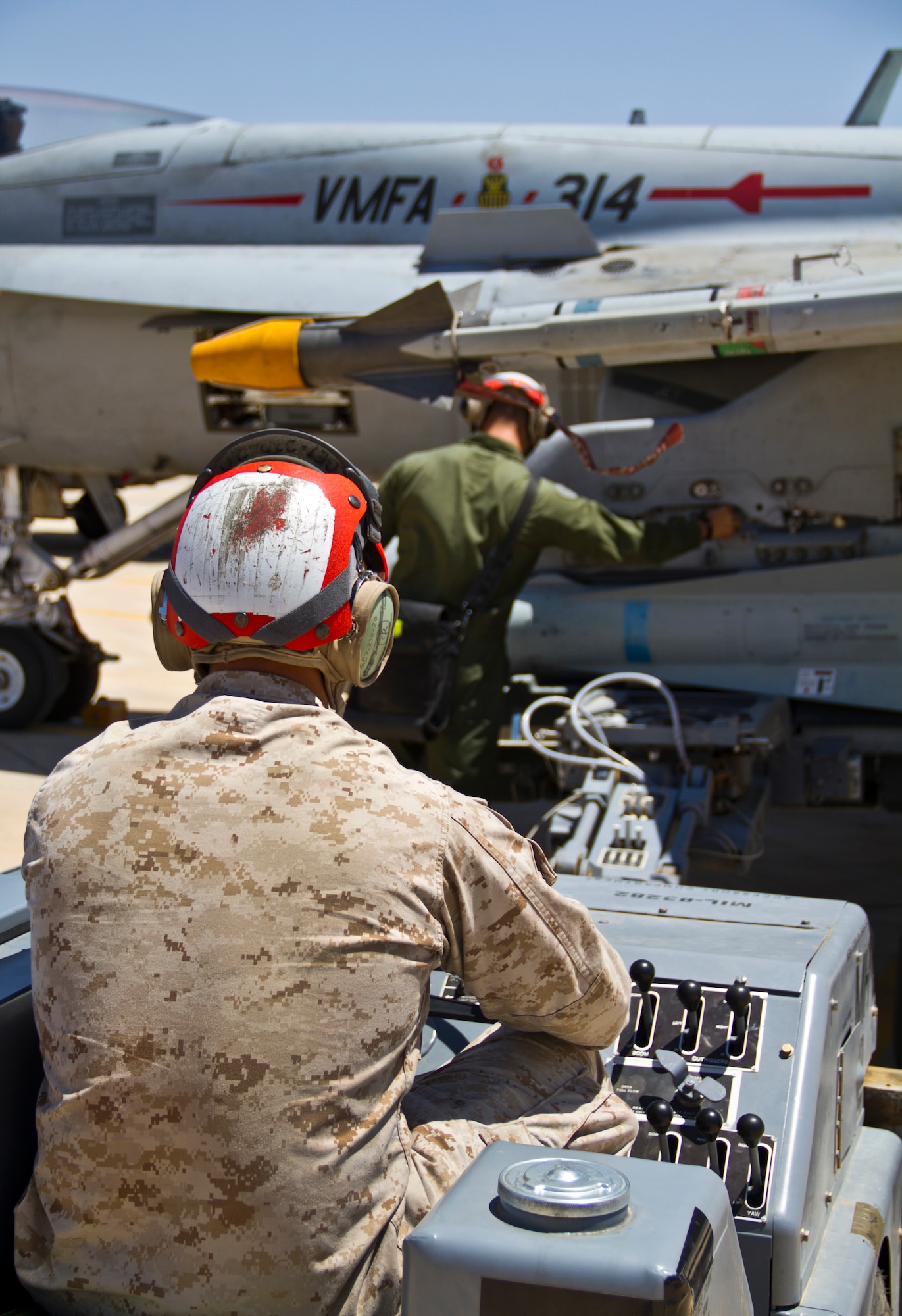 U.S. Marines from Marine Fighter Attack Squadron 314 at Marine Corps Air Station Miramar, Calif., test aircraft systems on an F-18 Hornet during Exercise Eager Lion June 1, 2014, at an air base in northern Jordan. Aircraft from all branches of the U.S. military flew alongside partner nations during this annual exercise. (U.S. Air Force photo by Staff Sgt. Tyler McLain/Released)