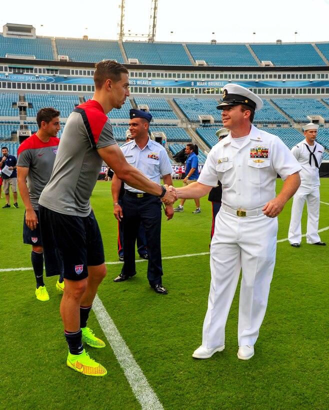 Navy Chief Roger Weakley, right, shakes hands with Geoff Cameron, a defender on the U.S. Men's National Soccer Team, during a dog tag ceremony at Everbank Stadium, Jacksonville, Fla., June 6, 2014. As a token of support and appreciation, each member of the soccer team was honored with custom 2014 FIFA World Cup dog tags presented by service members representing each branch of military service. Weakley is an electronics technician.