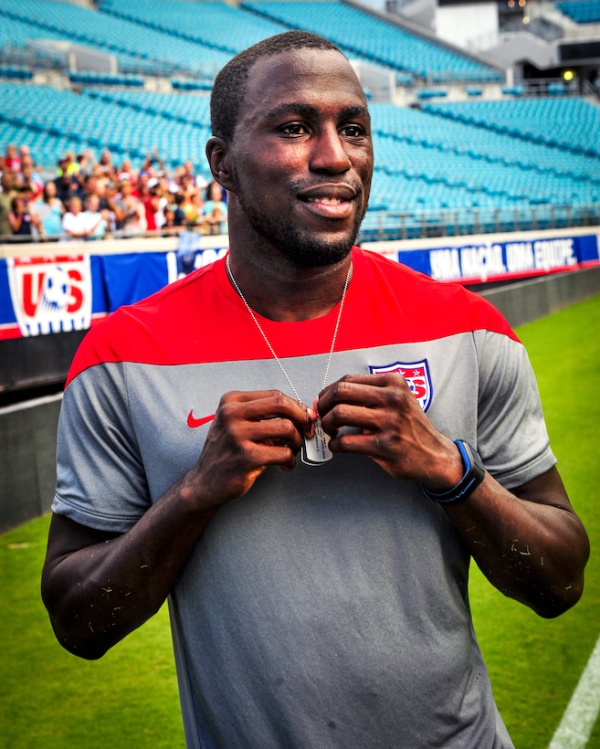 Jozy Altidore, a forward on the U.S. Men's National Soccer Team, holds his custom 2014 FIFA World Cup dog tag following a ceremony after an open practice for fans at Everbank Stadium, Jacksonville, Fla., June 6, 2014.
