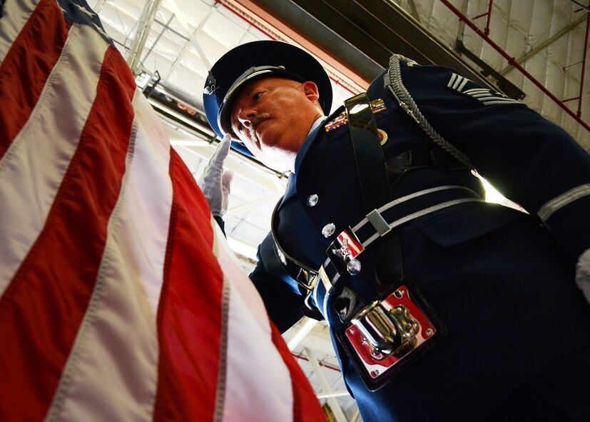 PEASE AIR NATIONAL GUARD BASE, N.H. -- Chief Master Sgt. Michael Bascom salutes the flag during the presentation of colors at the start of Chief Master Sgt. Brenda Blonigen's retirement ceremony in Hanger 254 here, June 7. Blonigen retired after 34 years of service on active duty and the Air National Guard. (U.S. Air Force photo by Tech. Sgt. Mark Wyatt)