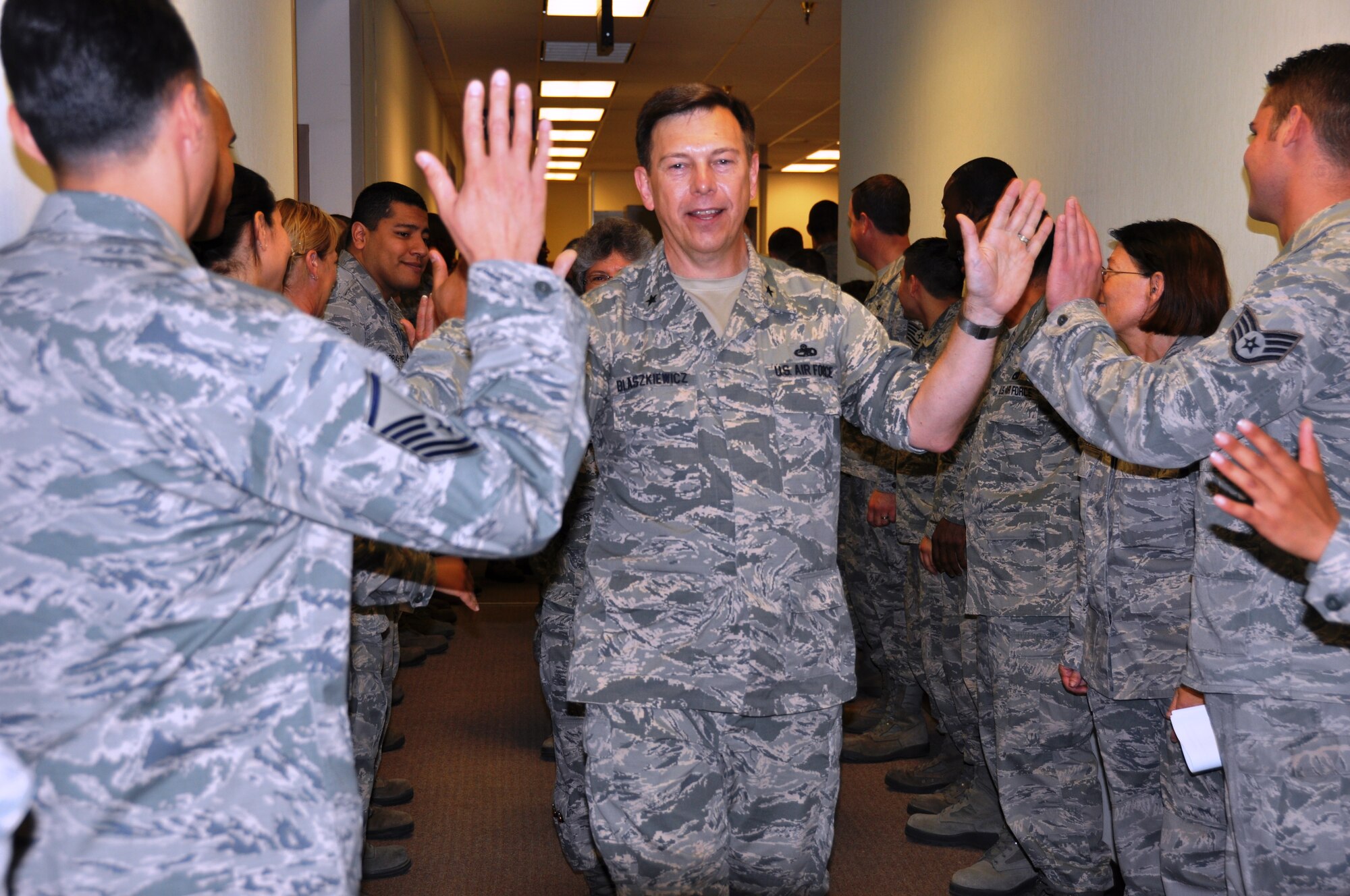 Brig. Gen.  Gary Blaszkiewicz, Director of Logistics, Headquarters Air Force Reserve Command receives high fives as he exits the 26th and 74th Aerial Port Squadron on June 8, 2014 at Joint Base San Antonio-Lackland, Texas. General Blaszkiewicz briefed the aerial porters on deployments, capabilities and training. (U.S. Air Force photo by Tech Sgt. Carlos J. Trevino)