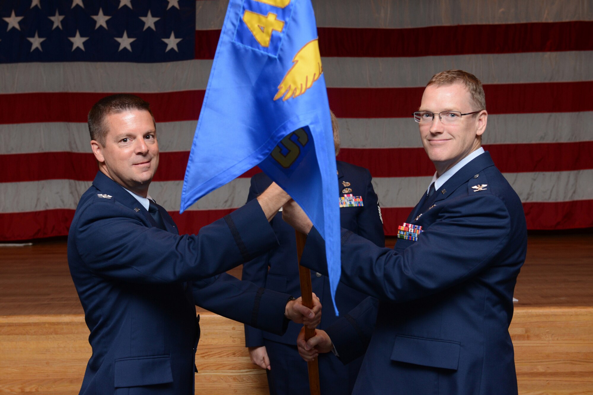 Col. Frank L. Amodeo, 403rd Wing commander (left), passes the guidon Col. John E. Buterbaugh, 403rd Aerial Port Squadron commander, during an assumption of command ceremony at the Keesler Medical Center, Keesler Air Force Base, Mississippi, June 7, 2014. Buterbaugh assumed command of the 403rd ASTS during the 403rd Wing June unit training assembly. (U.S. Air Force photo/Tech. Sgt. Ryan Labadens)