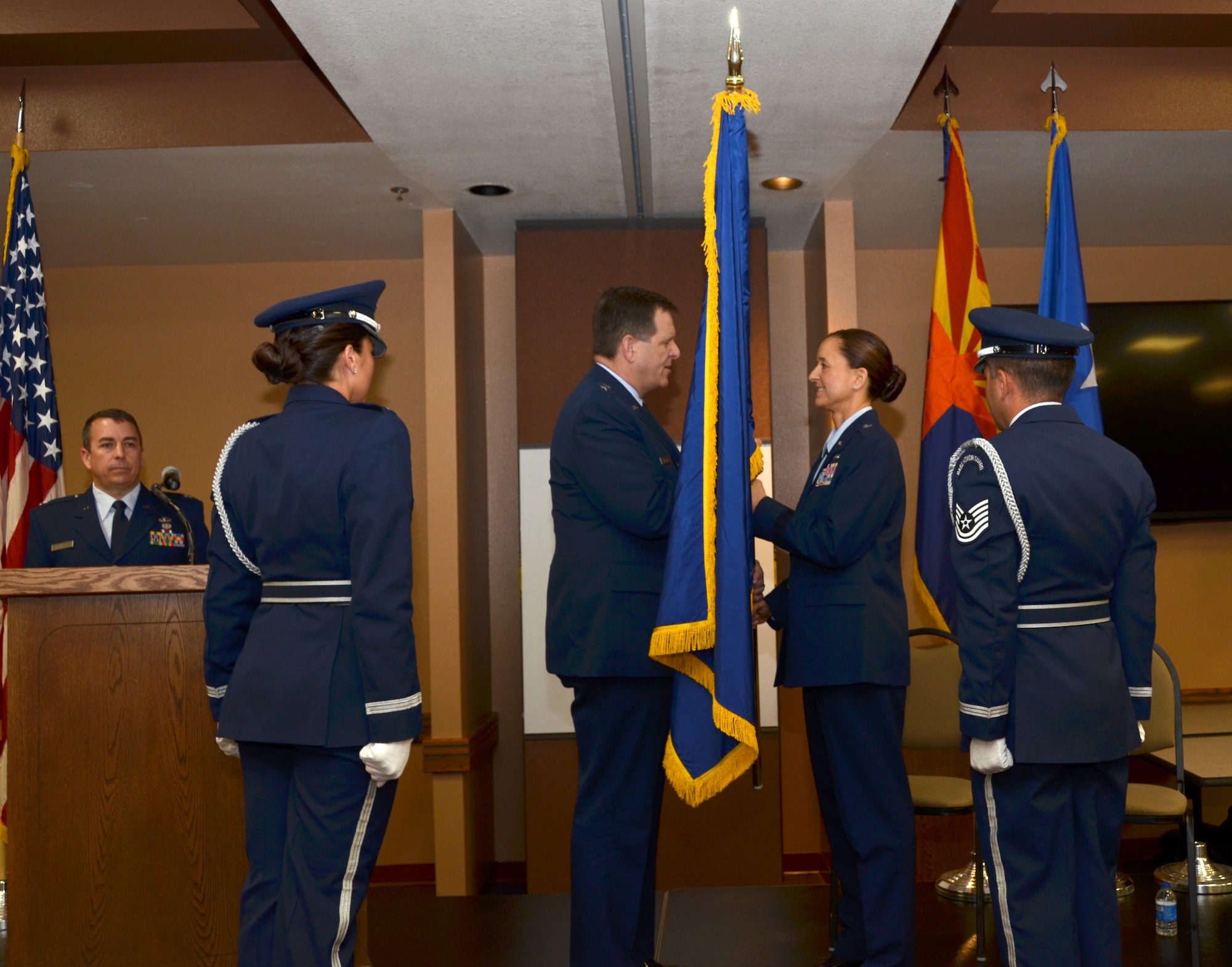 U.S. Air Force Brig. Gen. Michael McGuire, the Adjutant General of Arizona, presents Brig. Gen. Kerry L. Muehlenbeck, Arizona Army and Air Guard Joint Operations officer, a general’s flag during her promotion ceremony at the 161st Air Refueling Wing, Phoenix, June 7, 2014. Brig. Gen. Muehlenbeck is the first woman to serve as a general officer in the Arizona Air National Guard. (U.S. Air National Guard photo by Senior Airman Rashaunda Williams/Released)