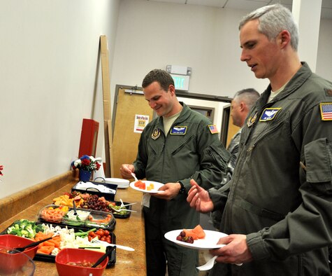 From left, Staff Sgt. Mike Solin, loadmaster, and Maj. Jim Wilson, pilot, both from the 97th Airlift Squadron help themselves to some refreshments June 8 at Joint Base Lewis-McChord - McChord Field, Washington. In addition to a change of command ceremony welcoming new squadron commander Lt. Col. Michael Bautista, personnel from the 97th AS also celebrated its 71st birthday at a local restaurant in Tacoma, Washington. (U.S. Air Force Reserve photo by Tech. Sgt. Minnette Mason)