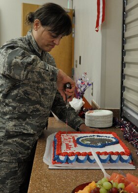 Chief Master Sgt. Mary Smith, chief of aviation and resource with the 97th Airlift Squadron, cuts cake June 8 at Joint Base Lewis-McChord - McChord Field, Washington. In addition to a Change of Command Ceremony welcoming new squadron commander Lt. Col. Michael Bautista, personnel from the 97th AS also celebrated its 71st birthday at a local restaurant in Tacoma, Washington. (U.S. Air Force Reserve photo by Tech. Sgt. Minnette Mason)