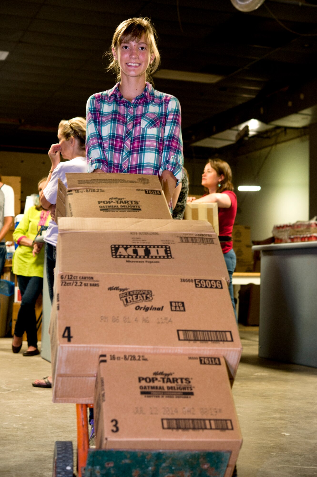 Kennedi McGee, daughter of Staff Sgt. Larissa McGee, 442nd Logistics Readiness Squadron, and Master Sgt. Cory McGee, 509th Civil Engineer Squadron, moves boxes at the Warrensburg United Way June 7, 2014, in Warrensburg, Mo. About 100 boxes were filled for care packages to send to deployed members of the 442nd Fighter Wing. (U.S. Air Force photo by Senior Airman Daniel Phelps/Released)