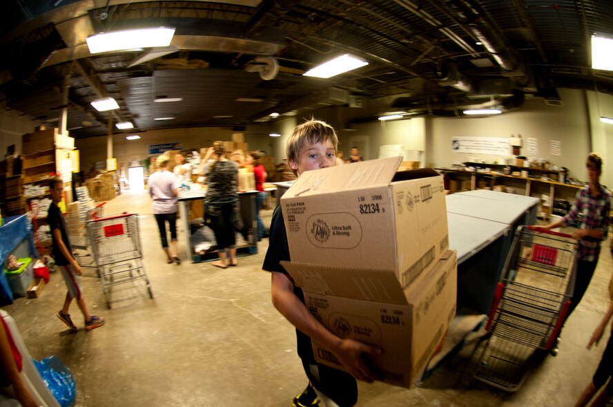 A military dependent carries boxes to be processes at the Warrensburg United Way June 7, 2014, in Warrensburg, Mo. Boxes were filled for care packages to send to deployed members of the 442nd Fighter Wing. (U.S. Air Force photo by Senior Airman Daniel Phelps/Released)