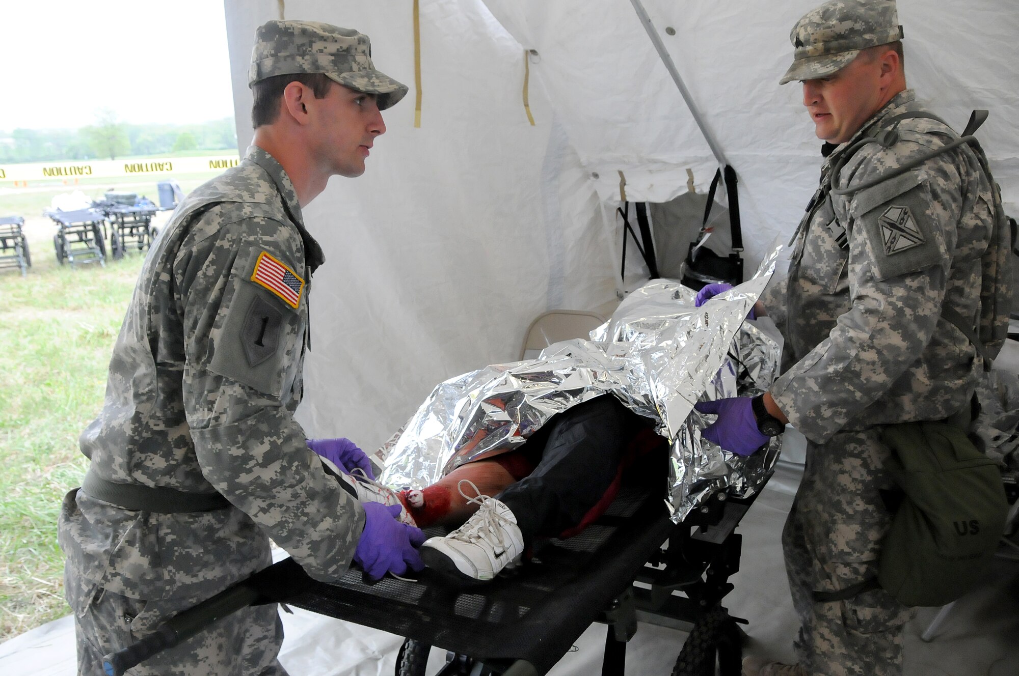 Army Sgt. Jacob Schmidt, Va. Army National Guard Medical Command healthcare specialist (left), and Army Sgt. David Samuel, Va. Army National Guard Medical Command combat medic (right), treat a “patient” as part of the three-day Vigilant Guard exercise at Fort Indiantown Gap, Pa., May 14, 2014.  The 192nd MDG participated in the exercise to enhance their Chemical, Biological, Radiological, Nuclear, and Explosive (CBRNE) Enhanced Response Force Package (CERFP) training in which they used the medical triage to assess “patients” and direct them to the correct tent for treatment.  The CERFP conducts tasks associated with incident management, search and rescue, mass casualty decontamination, medical triage, and fatality recovery.  (U.S. Air National Guard photo by Airman 1st Class Johnisa B. Roberts/Released)