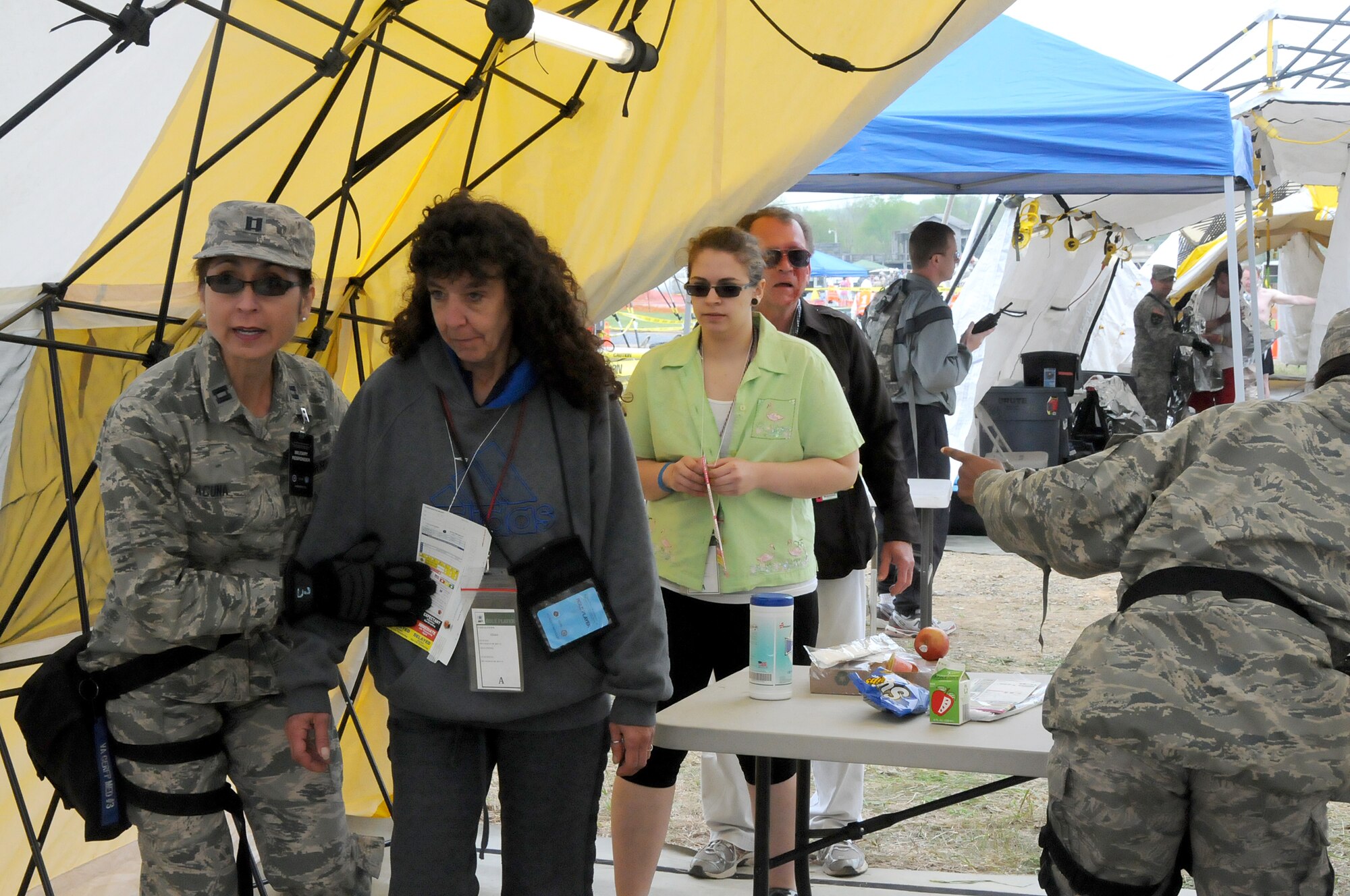 Capt. Delia Acuna, 192nd Fighter Wing Medical Group critical care nurse, escorts several “patients” to treatment tents as part of the three-day Vigilant Guard exercise at Fort Indiantown Gap, Pa., May 14, 2014.  The 192nd MDG participated in the exercise to enhance their Chemical, Biological, Radiological, Nuclear, and Explosive (CBRNE) Enhanced Response Force Package (CERFP) training in which they used the medical triage to assess “patients” and direct them to the correct tent for treatment. The CERFP conducts tasks associated with incident management, search and rescue, mass casualty decontamination, medical triage, and fatality recovery.  (U.S. Air National Guard photo by Airman 1st Class Johnisa B. Roberts/Released)
