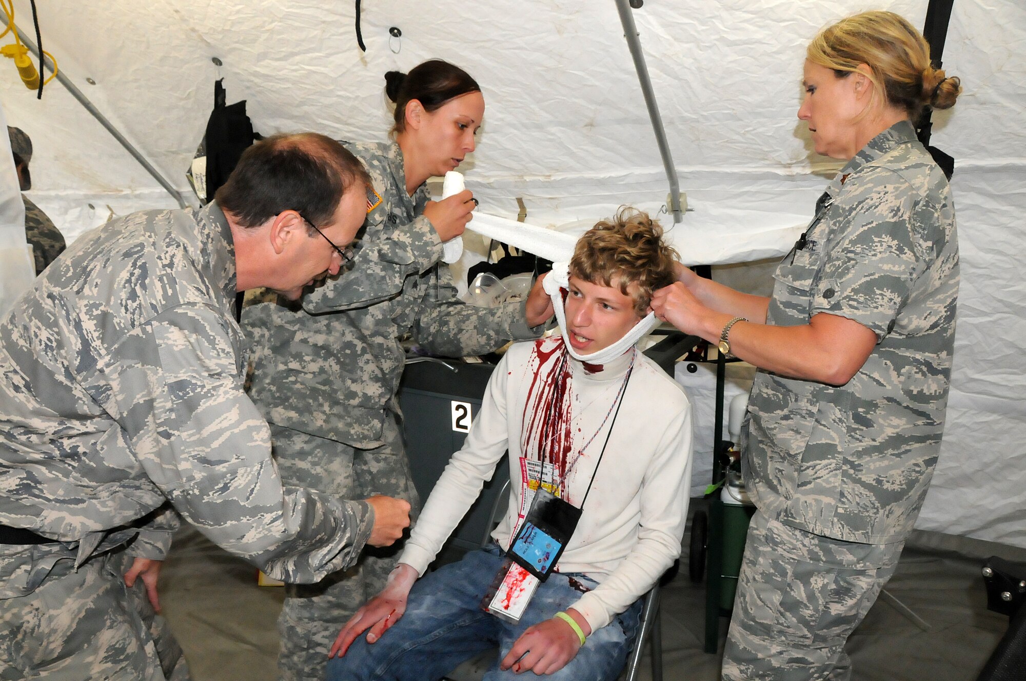 Lt. Col. John Janousek, 192nd Fighter Wing Medical Group flight surgeon (left); Army Sgt. Ashleigh Hass, Va. Army National Guard Medical Command at Fort Pickett combat medic (center); and Maj. Robyn Haren, 192nd MDG nurse practitioner (right), treat a “patient” as part of the thee-day Vigilant Guard exercise at Fort Indiantown Gap, Pa., May 14, 2014.  The 192nd MDG participated in the exercise to enhance their Chemical, Biological, Radiological, Nuclear, and Explosive (CBRNE) Enhanced Response Force Package (CERFP) training in which they used the medical triage to assess “patients” and direct them to the correct tent for treatment.  The CERFP conducts tasks associated with incident management, search and rescue, mass casualty decontamination, medical triage, and fatality recovery.  (U.S. Air National Guard photo by Airman 1st Class Johnisa B. Roberts/Released)