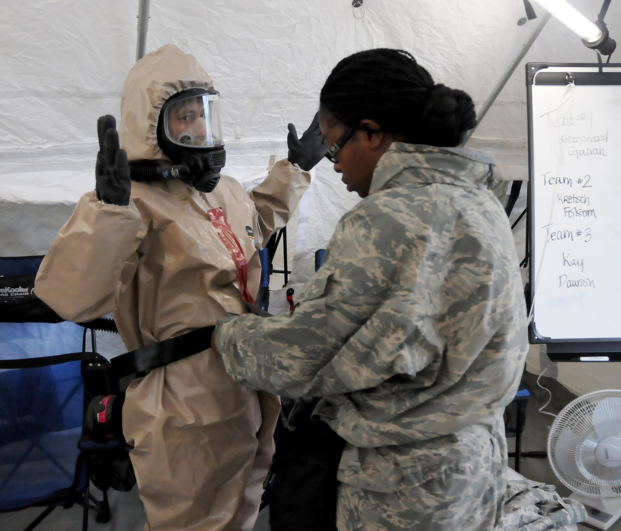 Tech. Sgt. Lanita Dawson, 192nd Fighter Wing Medical Group medical technician assists Senior Airman Zenaida Kretsch, 192nd MDG medical technician, with her chemical environment suit at Fort Indiantown Gap, Pa., May 14, 2014.  Kretsch went to the first stage where “patients” were gathered and evaluated for medical treatment. (U.S. Air National Guard photo by Airman 1st Class Johnisa B. Roberts/Released) 