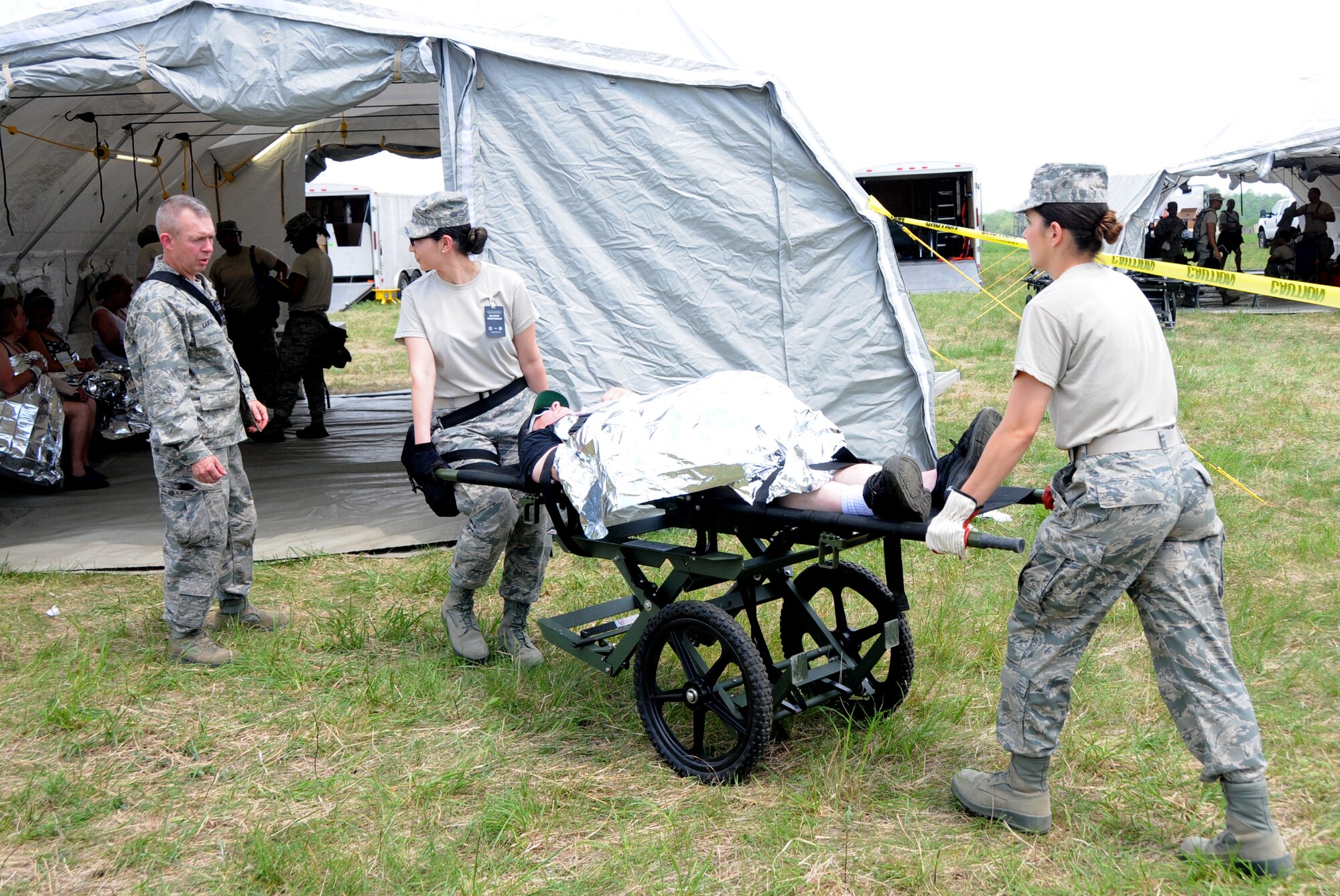 Airman 1st Class Beverly West, 192nd Fighter Wing Medical Group dental assistant (left), and Airman 1st Class Cassandra Horwath, 192nd MDG medical admin (right), transport a “patient” to a treatment tent for advanced life support and stabilization for trauma as part of the medical triage during the three-day Vigilant Guard exercise at Fort Indiantown Gap, Pa., May 13, 2014.  Medical triage is used to assess patients and direct them to the correct tent for treatment.  The 192nd MDG participated in the exercise to enhance their Chemical, Biological, Radiological, Nuclear, and Explosive (CBRNE) Enhanced Response Force Package (CERFP) training.  (U.S. Air National Guard photo by Airman 1st Class Johnisa B. Roberts/Released)