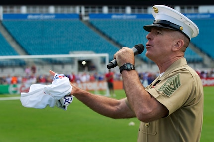 Marine Corps. Sgt. Maj. Bryan B. Battaglia, senior enlisted adviser to the chairman of the Joint Chiefs of Staff, revs up the crowd in the stands with a cheer - “U.S.A. all the way!" - before an open practice of the U.S. Men's National Soccer Team, for fans at Everbank Stadium, Jacksonville, Fla., June 6, 2014.