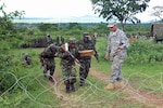 Uganda Peoples Defense Force soldiers demonstrate elements of a deliberate attack drill Army Sgt. 1st Class Curtis Stille, from 3rd Squadron, 124th Cavalry Regiment. The UPDF invited the U.S. Soldiers to participate in a best-practices exchange where they conducted various military-to-military exchanges in support of Combined Joint Task Force - Horn of Africa, whose mission is to build partnerships with nations in East Africa.