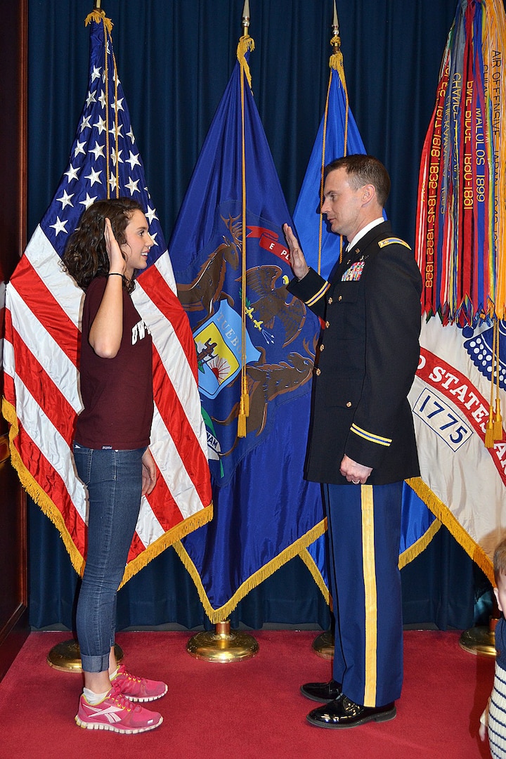Rylie Denson receives the Oath of Enlistment from her father, Maj. Doug Denson, executive officer of the 1st Battalion, 147th Aviation Regiment, during a swearing-in ceremony Feb. 25, 2014, in Milwaukee. Rylie became the third generation of Densons to serve in the unit when she enlisted into the Wisconsin Army National Guard. Her grandfather, retired Brig. Gen. Kerry Denson, was the unit’s first commander. 