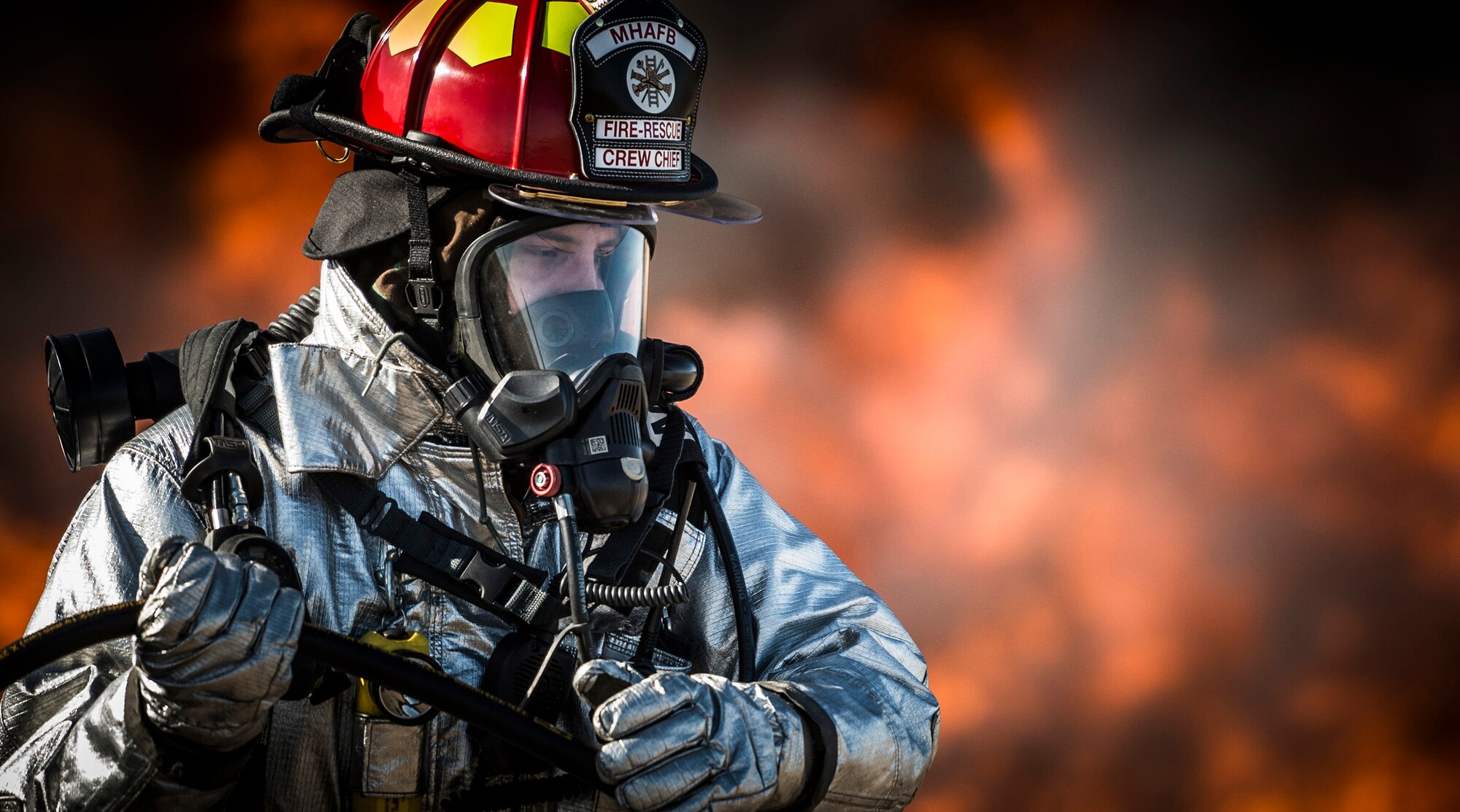 A firefighter from the 366th Civil Engineer Squadron pulls a fire hose during a base-wide operation readiness exercise March 4, 2013, at Mountain Home Air Force Base, Idaho. The Mountain Home AFB Fire Department was recently awarded the 2013 Department of Defense Fire and Emergency Services of the Year award in the small fire department category. (U.S. Air Force photo/Tech. Sgt. Samuel Morse)