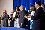 First Lady Michelle Obama holds the "Military Family Licensing Act," which will help military spouses and veterans transfer their professional licenses to Illinois more easily, during a signing ceremony in Chicago, June 26, 2012. Illinois Gov. Pat Quinn, to the right of the First Lady, signed the act.