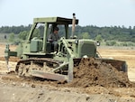 Spc. Donald Pace, of the 207th Horizontal Engineer Company, operates a D7 bulldozer to move dirt in efforts to build a new contingency operations location at Wendell H. Ford Regional Training Center in Greenville, Ky. Soldiers from the 201st and 206th Engineer Battalions worked on building living quarters, access roads and performed preliminary site surveys of a proposed air strip at the site.(U.S. Army Photo by Sgt. Sandra Fariss)