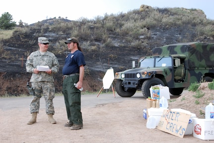 pc. Daniel Evanson, from the Colorado Army National Guard's 193rd Military Police Battalion, looks over an updated fire plan with Mark De Gregorio, of the National Park Service, who is also on call for fire support with various incident management teams near Fort Collins, Colo. The Colorado National Guard is assisting the Larimer Country Sheriff's Office with evacuation and to protect personnel and property during the High Park fire. "It's very comforting to the people who live up here to have these troops up here securing access to their evacuated homes," said De Gregorio.