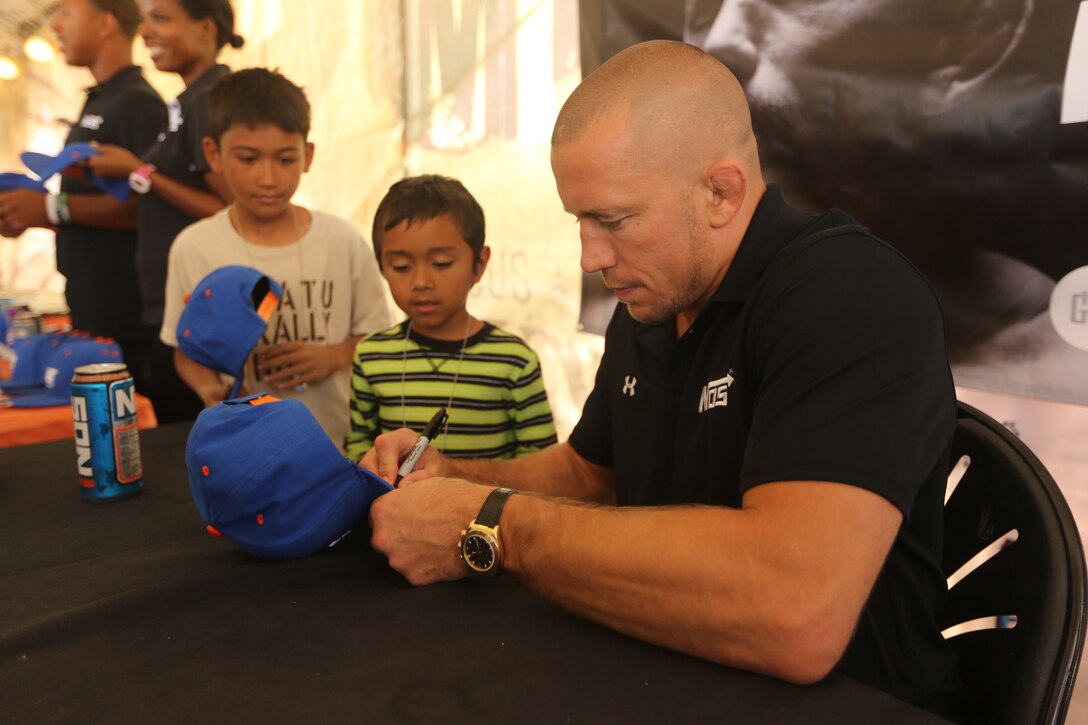Georges St-Pierre, mixed martial artist and UFC world champion, meets Marine volunteers and runners at the 22nd World Famous Mud Run on Camp Pendleton June 8. St-Pierre took photos and signed autographs for Mud Run racers and service members during the visit.