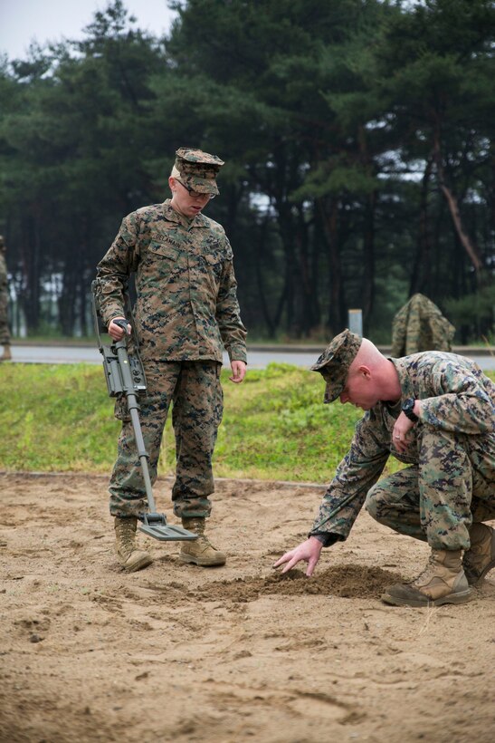 Sgt. Joshua K. Crabtree, right, instructs Pfc. Madison Delamain on the proper use of a compact metal detector June 3 on Camp Mujuk, Republic of Korea. Marines with 3rd Law Enforcement Battalion executed improvised explosive device recognition lane training as a refresher in preparation for Korean Marine Exchange Program 14-8. KMEP 14-8 is a combined, small-unit training exercise, which enhances the combat readiness and interoperability of ROK-U.S. Marine Corps forces. Crabtree is an explosive ordnance disposal technician with 3rd EOD Company, 9th Engineer Support Battalion, 3rd Marine Logistics Group, III Marine Expeditionary Force. Delamain is a military policewoman with 3rd LE Bn., III Marine Expeditionary Force Headquarters Group, III MEF. (U.S. Marine Corps photo by Lance Cpl. Drew Tech/Released)