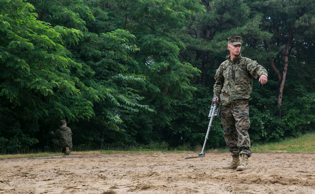 Lance Cpl. Daniel Lawler, right, directs members of his fire team to cordon off an area June 3 on Camp Mujuk, Republic of Korea. Marines with 3rd Law Enforcement Battalion executed improvised explosive device recognition lane training as a refresher in preparation for Korean Marine Exchange Program 14-8. KMEP 14-8 is a combined, small-unit training exercise, which enhances the combat readiness and interoperability of ROK-U.S. Marine Corps forces. Lawler is a military policeman with 3rd LE Bn., III Marine Expeditionary Force Headquarters Group, III Marine Expeditionary Force. (U.S. Marine Corps photo by Lance Cpl. Drew Tech/Released)