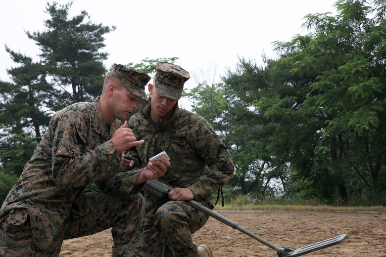 Lance Cpls. Robert C. Howell, left, and Daniel Lawler call in a simulated improvised explosive device June 3 on Camp Mujuk, Republic of Korea. Marines with 3rd Law Enforcement Battalion executed IED lane training as a refresher in preparation for Korean Marine Exchange Program 14-8. KMEP 14-8 is a combined, small-unit training exercise, which enhances the combat readiness and interoperability of ROK-U.S. Marine Corps forces. Howell and Lawler are military policemen with 3rd LE Bn., III Marine Expeditionary Force Headquarters Group, III MEF. (U.S. Marine Corps photo by Lance Cpl. Drew Tech/Released)
