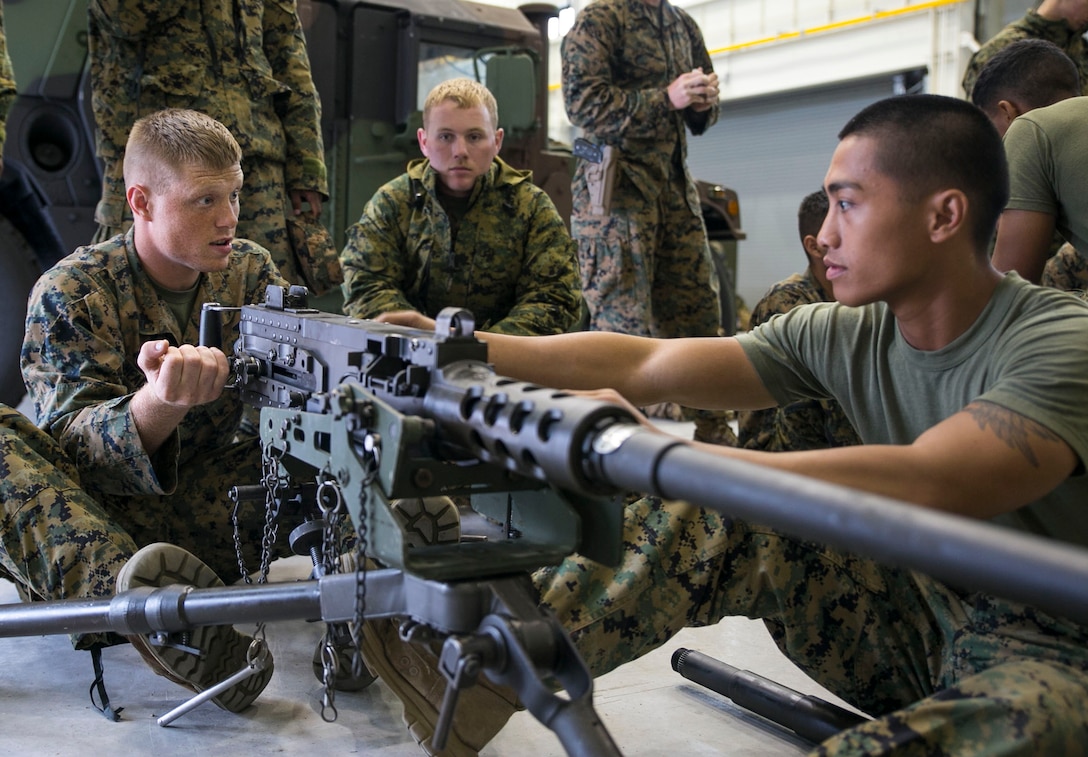 Sgt. Niko Azucenas, right, instructs Lance Cpl. Joshua Headworth, left, on the fundamentals of the M2 .50-caliber Browning machine gun June 5 on Camp Mujuk, South Korea. The U.S. Marines familiarized themselves with the crew served weapon to enhance safety on ranges where they will train Republic of Korea Marines on the weapons employment as part of Korean Marine Exchange Program 14-8. KMEP 14-8 is one iteration in a series of continuous combined training exercises designed to enhance the ROK-U.S. alliance, promote stability on the Korean Peninsula, and strengthen ROK-U.S. military capabilities and interoperability. Azucenas and Headworth are military policemen with 3rd Law Enforcement Battalion, III Marine Expeditionary Force Headquarters Group, III MEF. (U.S. Marine Corps photo by Lance Cpl. Drew Tech/Released)