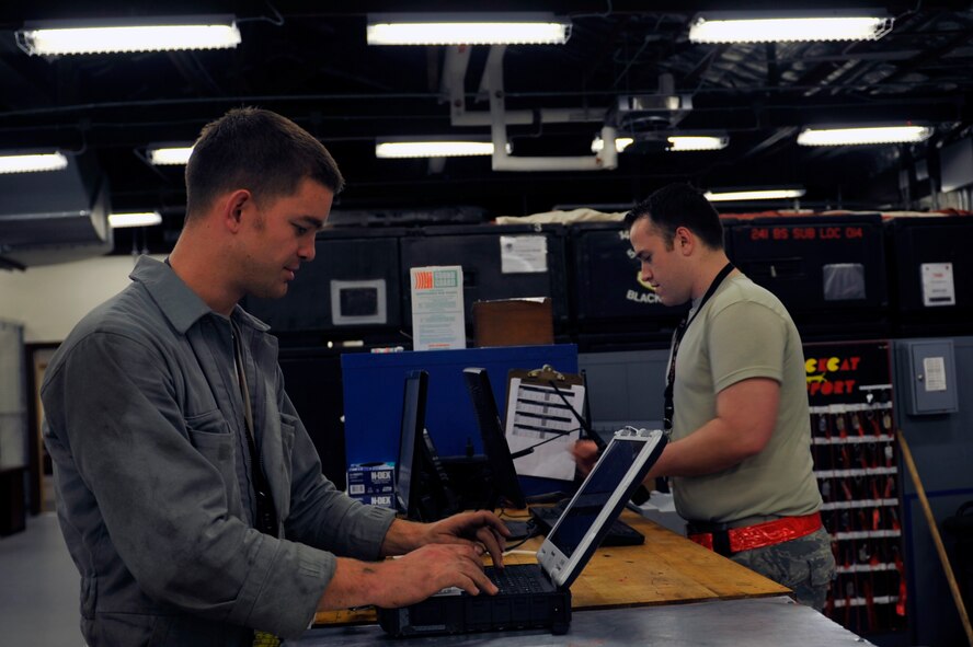 Senior Airman Peter McMurray, 5th Reconnaissance Squadron crew chief, left, checks out a technical order toughbook from the support section on Osan Air Base, Republic of Korea, May 15, 2014. The toughbook is used to facilitate maintenance on aircraft by providing Airmen with reference material. (U.S. Air Force photo/Senior Airman David Owsianka)