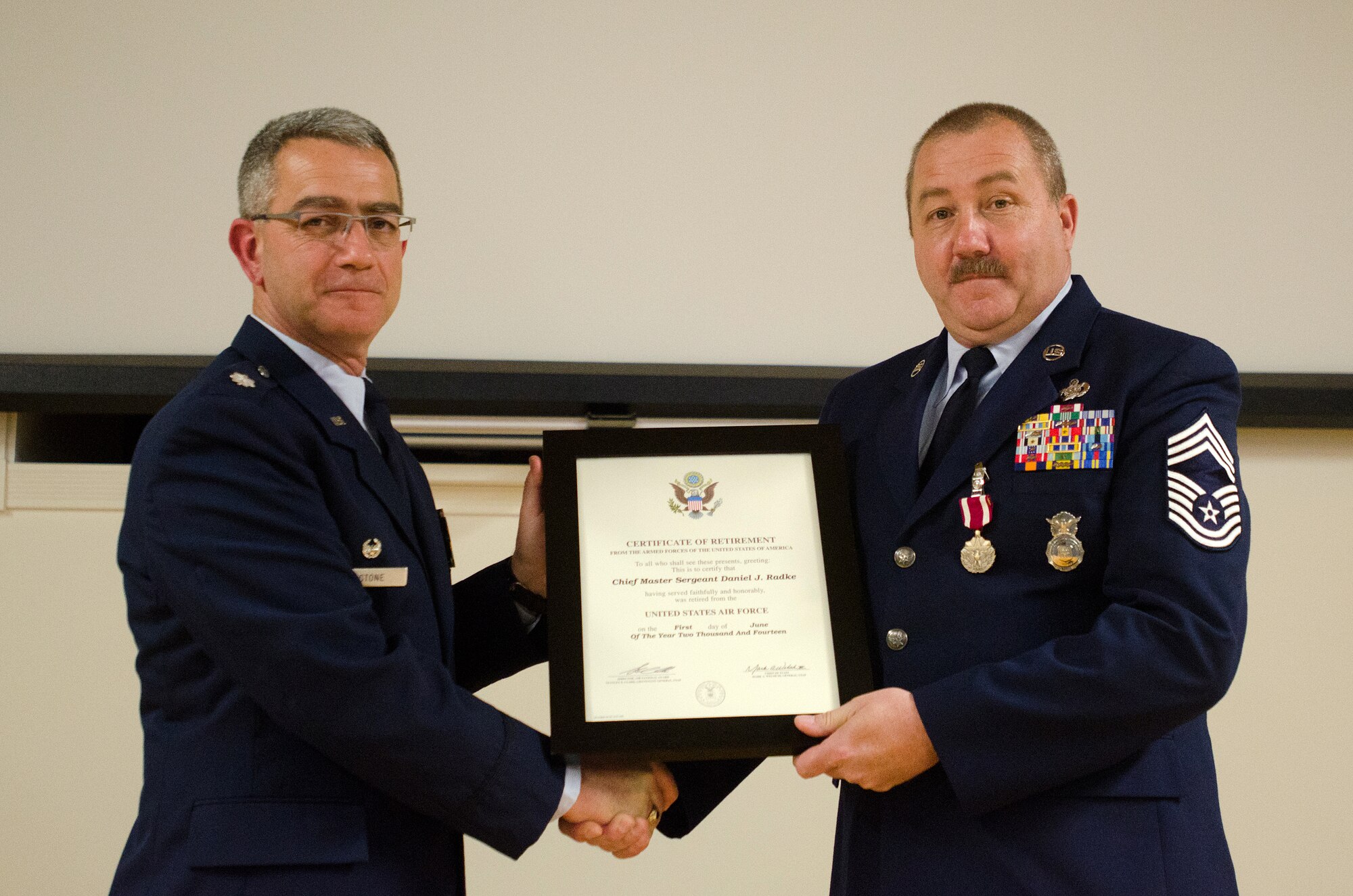 Lt. Col. Matthew L. Stone (left), commander of the 123rd Mission Support Group, presents the Certificate of Retirement to Chief Master Sgt. Daniel J. Radke, outgoing chief enlisted manager of the 123rd Security Forces Squadron, during Radke’s retirement ceremony at the Kentucky Air National Guard Base in Louisville, Ky., on April 27, 2014. Radke served in the active-duty Air Force and Air National Guard for 32 years. (U.S. Air National Guard photo by Airman 1st Class Joshua Horton)