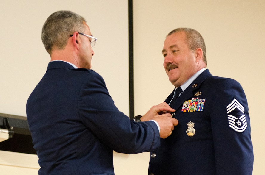 Lt. Col. Matthew L. Stone (left), commander of the 123rd Mission Support Group, pins the Meritorious Service Medal on Chief Master Sgt. Daniel J. Radke, outgoing chief enlisted manager of the 123rd Security Forces Squadron, during Radke’s retirement ceremony at the Kentucky Air National Guard Base in Louisville, Ky., on April 27, 2014. Radke served in the active-duty Air Force and Air National Guard for 32 years. (U.S. Air National Guard photo by Airman 1st Class Joshua Horton)