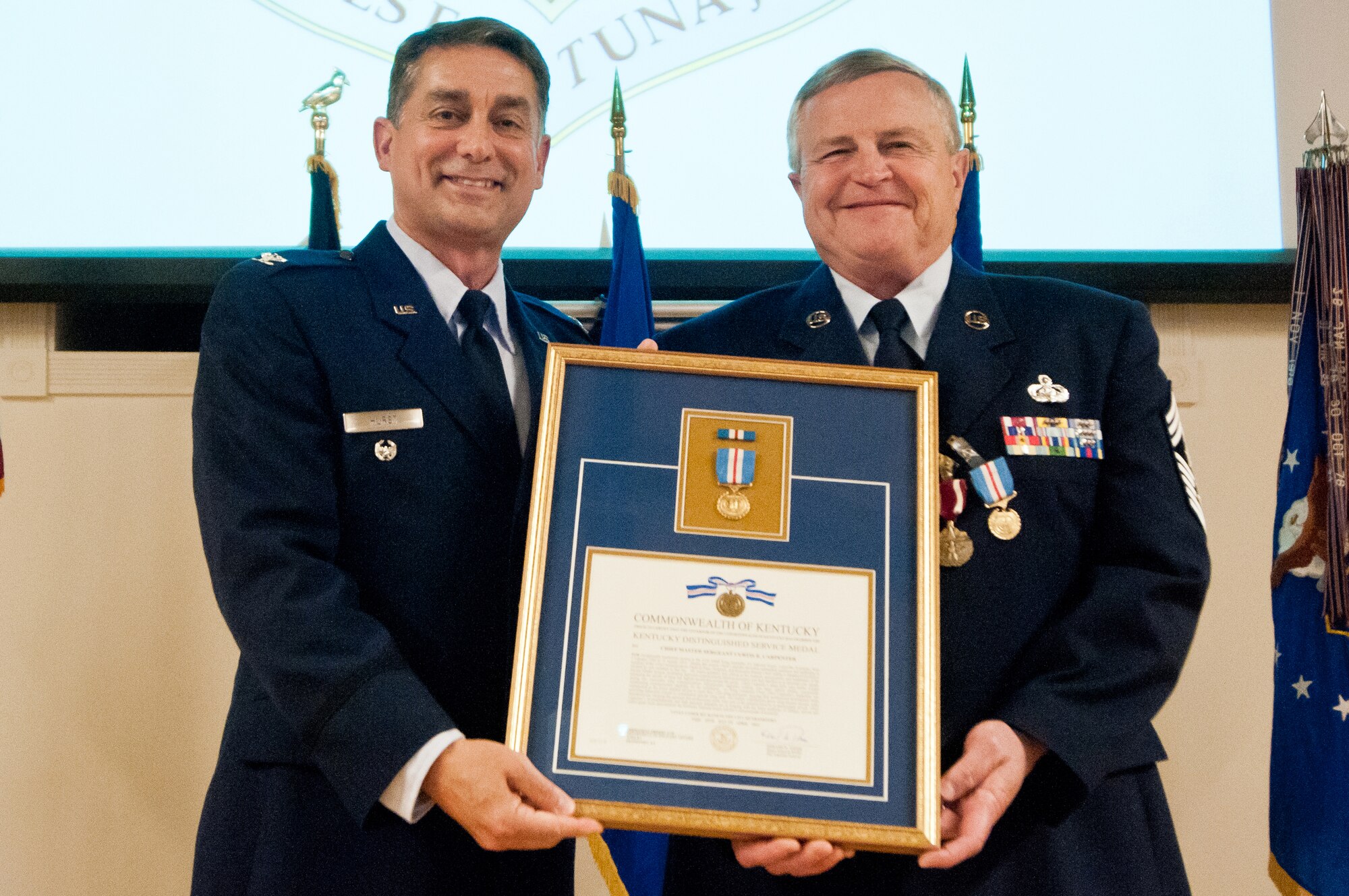 Col. Warren Hurst (left), Kentucky’s assistant adjutant general for Air, presents the Kentucky Distinguished Service Medal to Chief Master Sgt. Curtis R. Carpenter, outgoing 123rd Airlift Wing command chief, during Carpenter’s retirement ceremony at the Kentucky Air National Guard Base in Louisville, Ky., on May 17, 2014. Carpenter served in the active-duty Air Force and Air National Guard for more than 34 years. (U.S. Air National Guard photo by Airman 1st Class Joshua Horton)