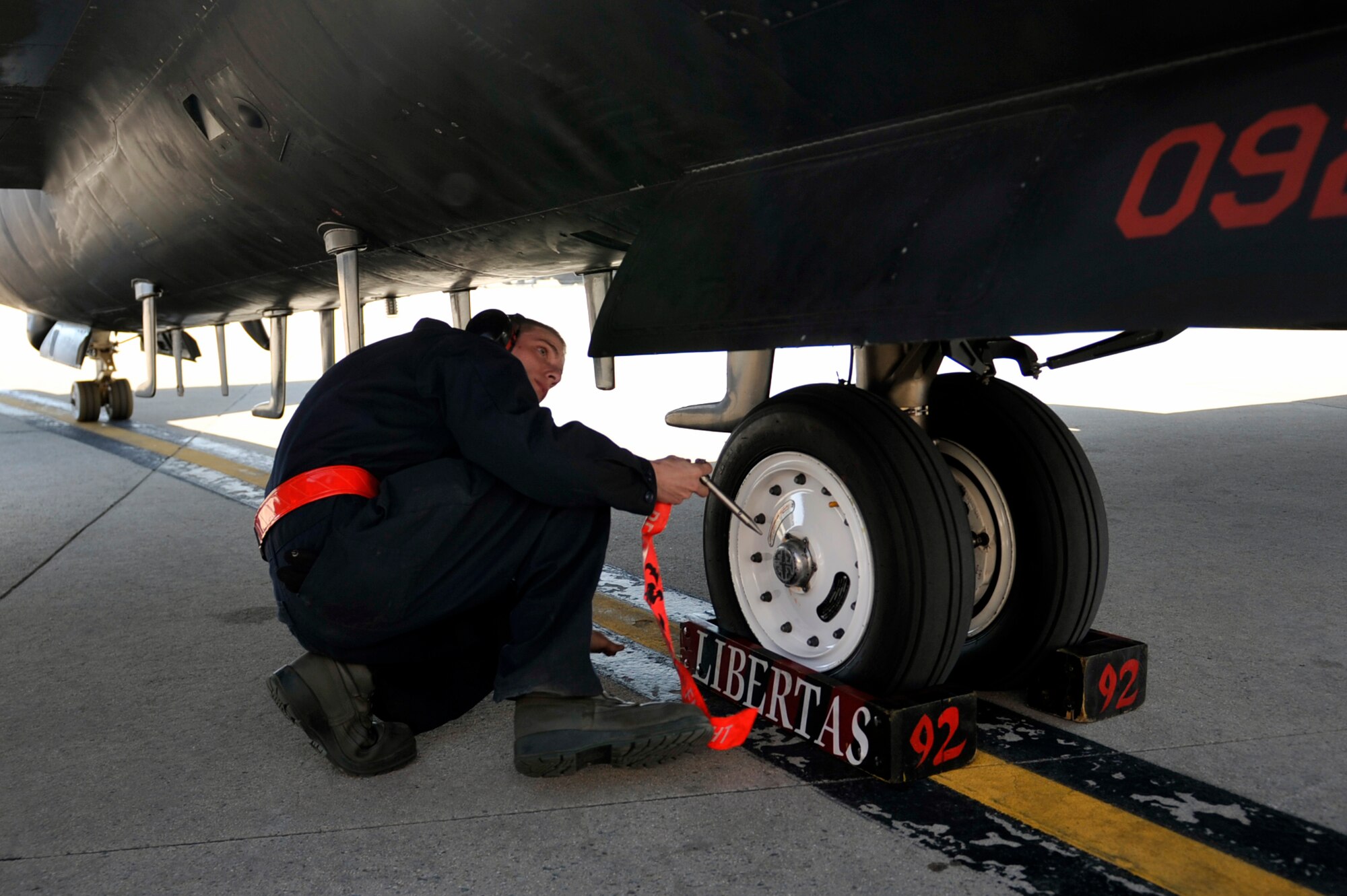 Airman 1st Class Caleb Deaton, 5th Reconnaissance Squadron crew chief, places aircraft chocks and a main landing gear pin on a U-2 Dragon Lady during the recovery phase prior to the engine shutting down on Osan Air Base, Republic of Korea, May 15, 2014. Crew chiefs perform a post-flight inspection at the end of the flying day to ensure the aircraft is structurally fit for its next flight. (U.S. Air Force photo/Senior Airman David Owsianka)