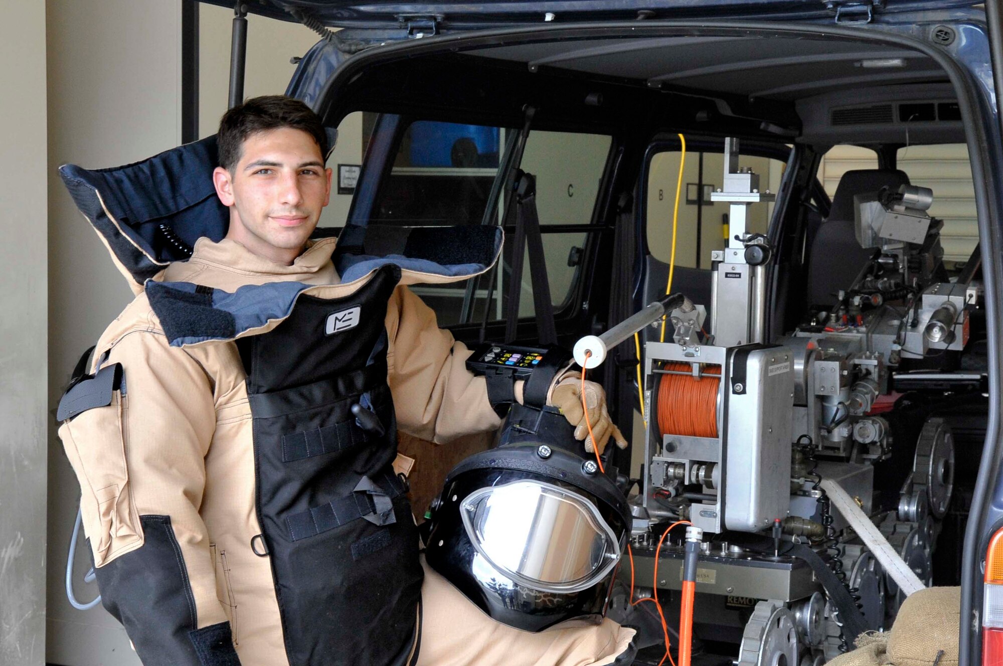 U.S. Air Force Airman 1st Class Marc Cooperman, 35th Civil Engineer Squadron explosive ordnance disposal technician poses in his bomb suit next to his EOD robot at Misawa Air Base, Japan, June 6, 2014. Cooperman’s suit is designed with layers of Kevlar, plastic and foam panels to protect him from the pressure an explosive generates. The suit is also equipped with a ventilation unit to keep the wearer from overheating. (U.S. Air Force photo/Airman 1st Class Patrick Ciccarone)