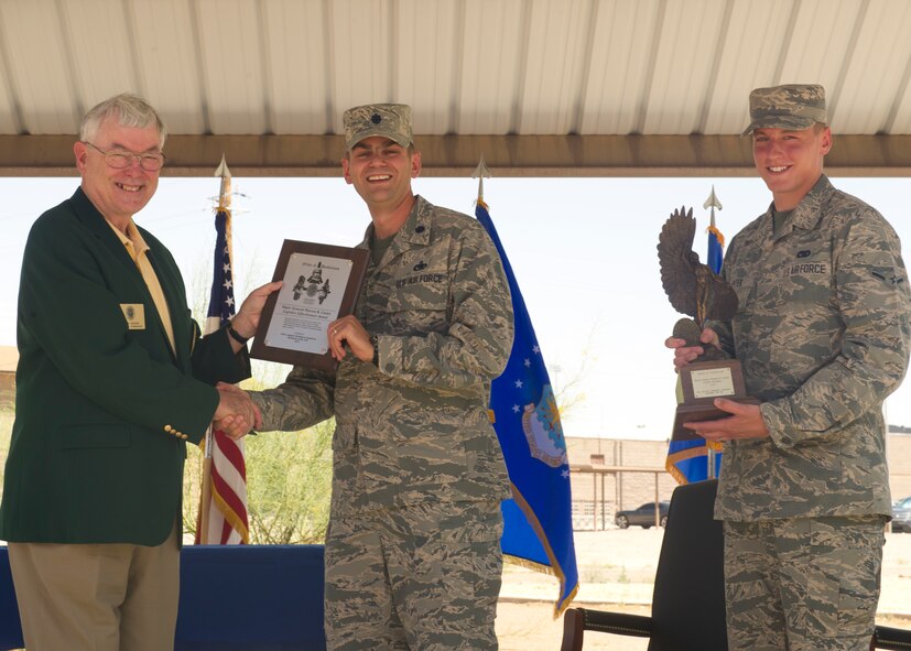 Retired Lt.Gen. Nicholas Kehoe presents awards to Lt. Col. Robert Bearden, 49th Logistics Readiness Squadron commander, and Airman Dylan Pentek, 49th LRS vehicle operator, during the Daedalion Award ceremony at Holloman Air Force Base, N.M., June 6. Holloman’s LRS was once again awarded the title of best LRS in the U.S. Air Force for 2013. The Maj. Gen. Warren R. Carter Logistics Readiness Squadron Effectiveness Award is presented annually by the Order of Daedalions to the base that has achieved the best supply effectiveness record in the U.S. Air Force in support of mission aircraft and weapons. (U.S. Air Force photo by Airman 1st Class Leah Ferrante/Released)