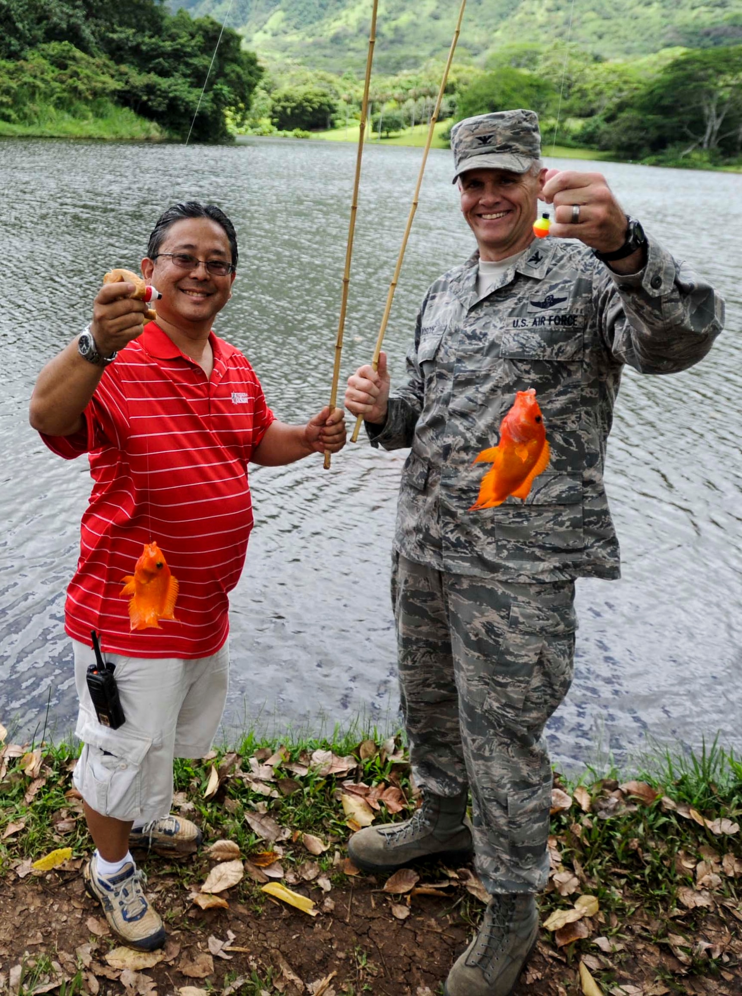 Wayne Iseri, Friends of Hickam president, and Col. Johnny Roscoe, 15th Wing commander, pose with their catch after competing to see who would catch the first fish of the day to kick off the 15th Annual Keiki Fishing Tournament at the Ho’omaluhia Botanical Garden in Kaneohe, Hawaii, June 4, 2014. The Keiki Fishing Tournament is a free event hosted by the Friends of Hickam organization to support, promote and foster strong community relations with military families. (U.S. Air Force photo/Tech. Sgt. Terri Paden)